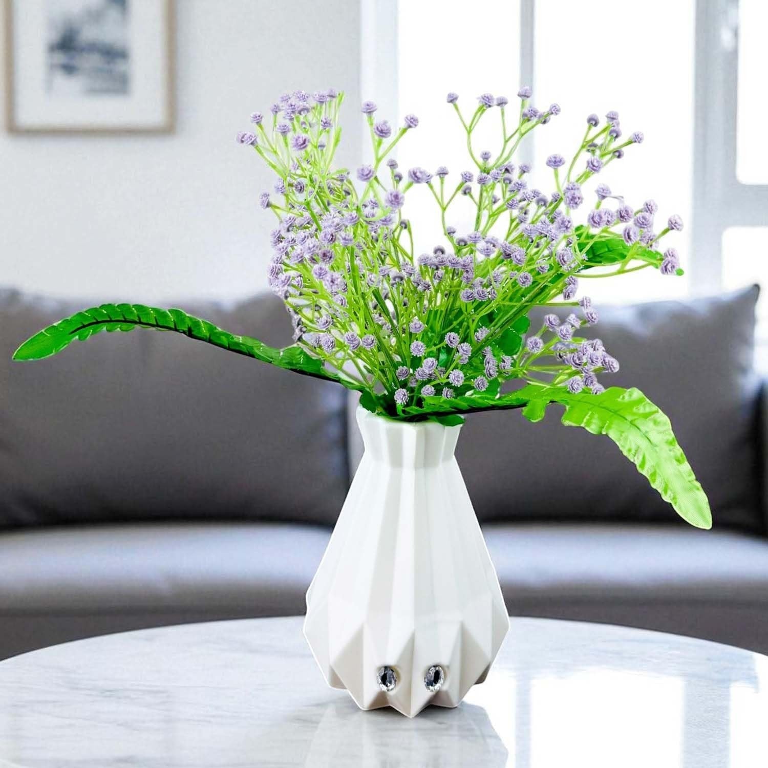 Go Hooked lavender baby's breath artificial flowers with green fern leaves in a white geometric vase.