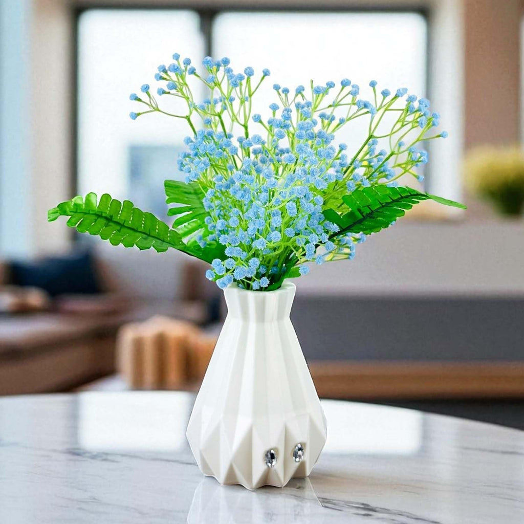 Go Hooked light blue baby's breath artificial flowers with green fern leaves in a white geometric vase.