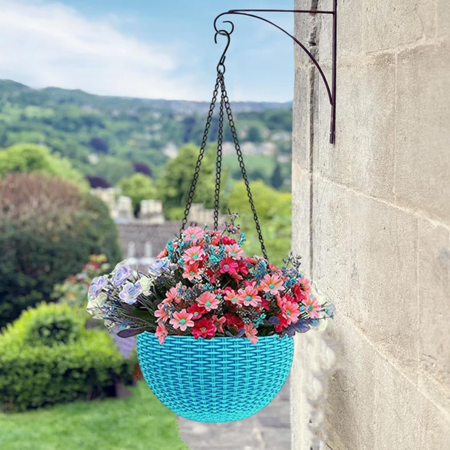 GoHooked light blue round plastic hanging planter with woven rattan look, filled with colorful flowers.