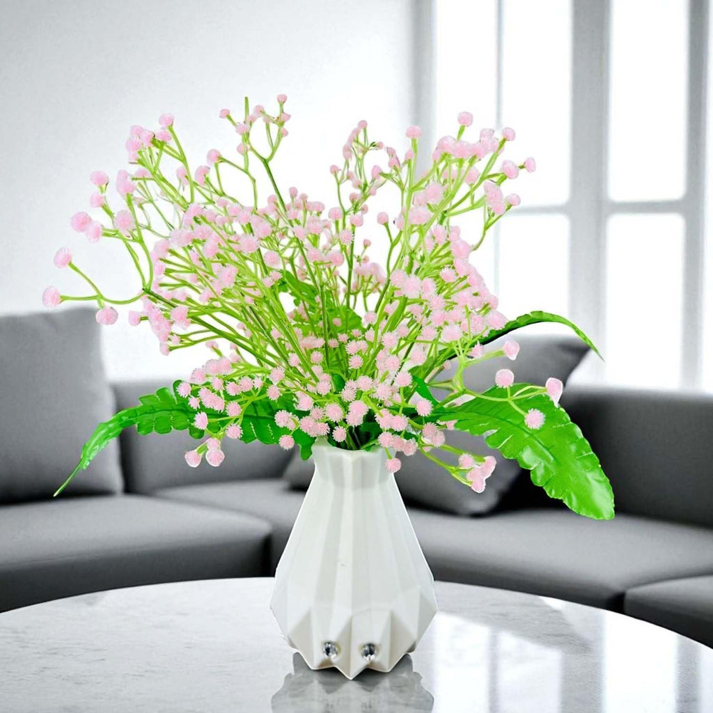 Go Hooked light pink baby's breath artificial flowers with fern leaves in a white geometric vase.
