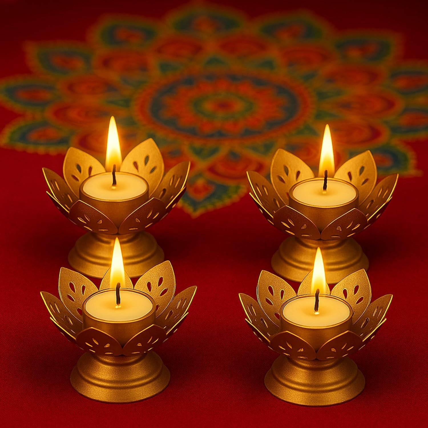 GoHooked set of 4 matte gold lotus tealight holders with lit candles on a red surface with a colorful mandala pattern behind.