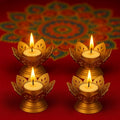 GoHooked set of 4 matte gold metal lotus tealight holders with lit candles, perfect for Diwali decor.