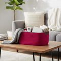 GoHooked magenta rectangular cotton rope storage basket with PU leather handles, holding books and a remote.