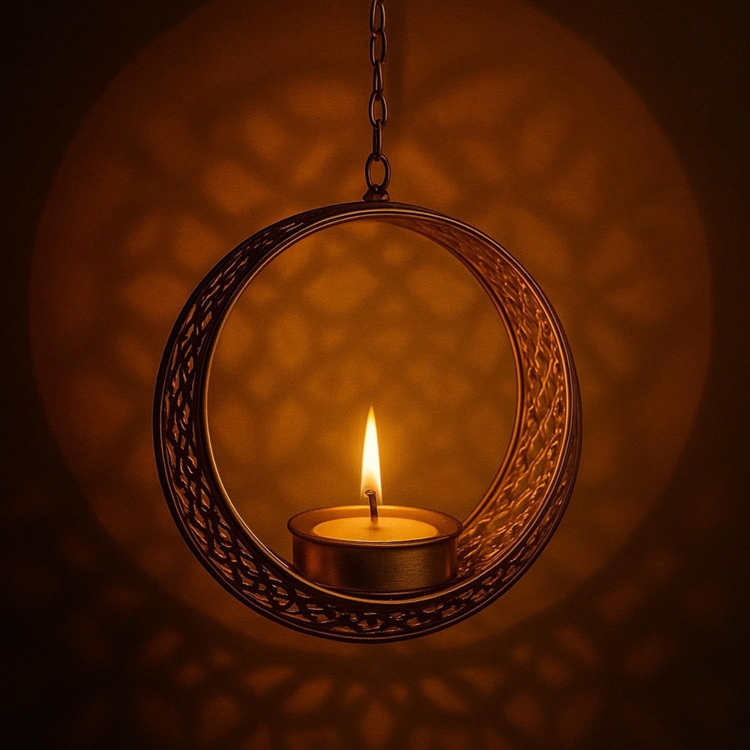 GoHooked matte gold round hanging tealight holder with intricate cutwork and a lit tealight candle.