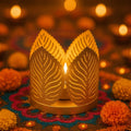 Go Hooked matte gold metal tealight holder with leaf cut design, casting warm light. Set of 2.