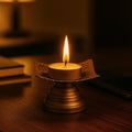 Go Hooked matte gold metal tealight candle holder with floral cutouts and a lit candle.