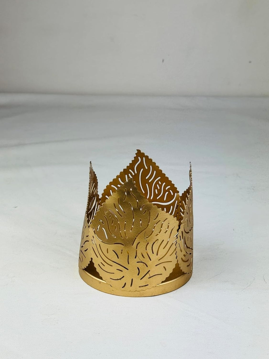 Go Hooked matte gold metal tealight holder with crown shape and leaf cut design. Set of 2.