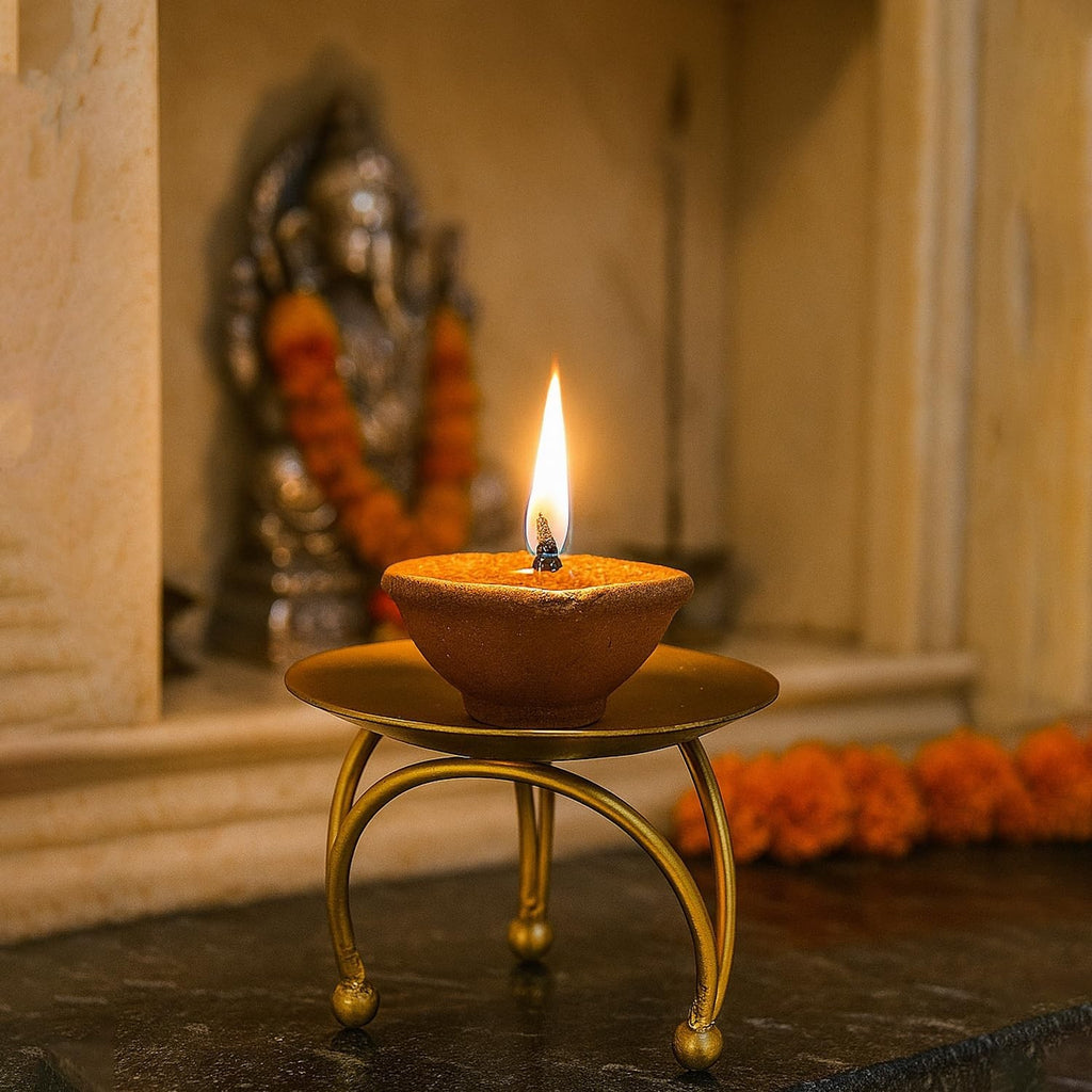GoHooked matte gold metal pedestal stand with a lit diya, set of 3, ideal for Diwali decor.