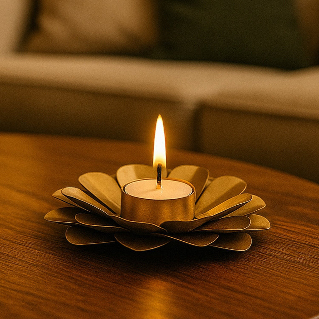 GoHooked matte gold metal flower tealight holder with layered petals, holding a lit tealight candle.