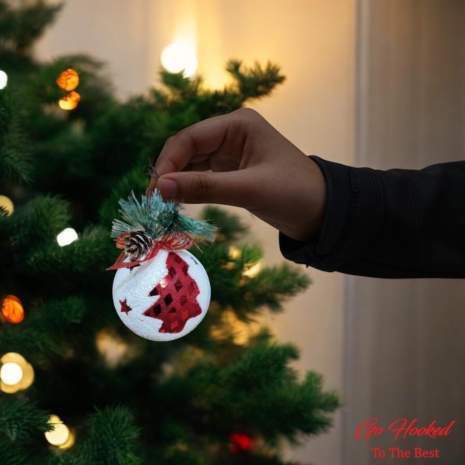 Go Hooked multicolor glitter Christmas tree ornament with red tree design, pinecone, and ribbon.