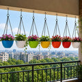 GoHooked pack of 7 multicolor round diamond plastic hanging planters with metal chains on a balcony garden railing.