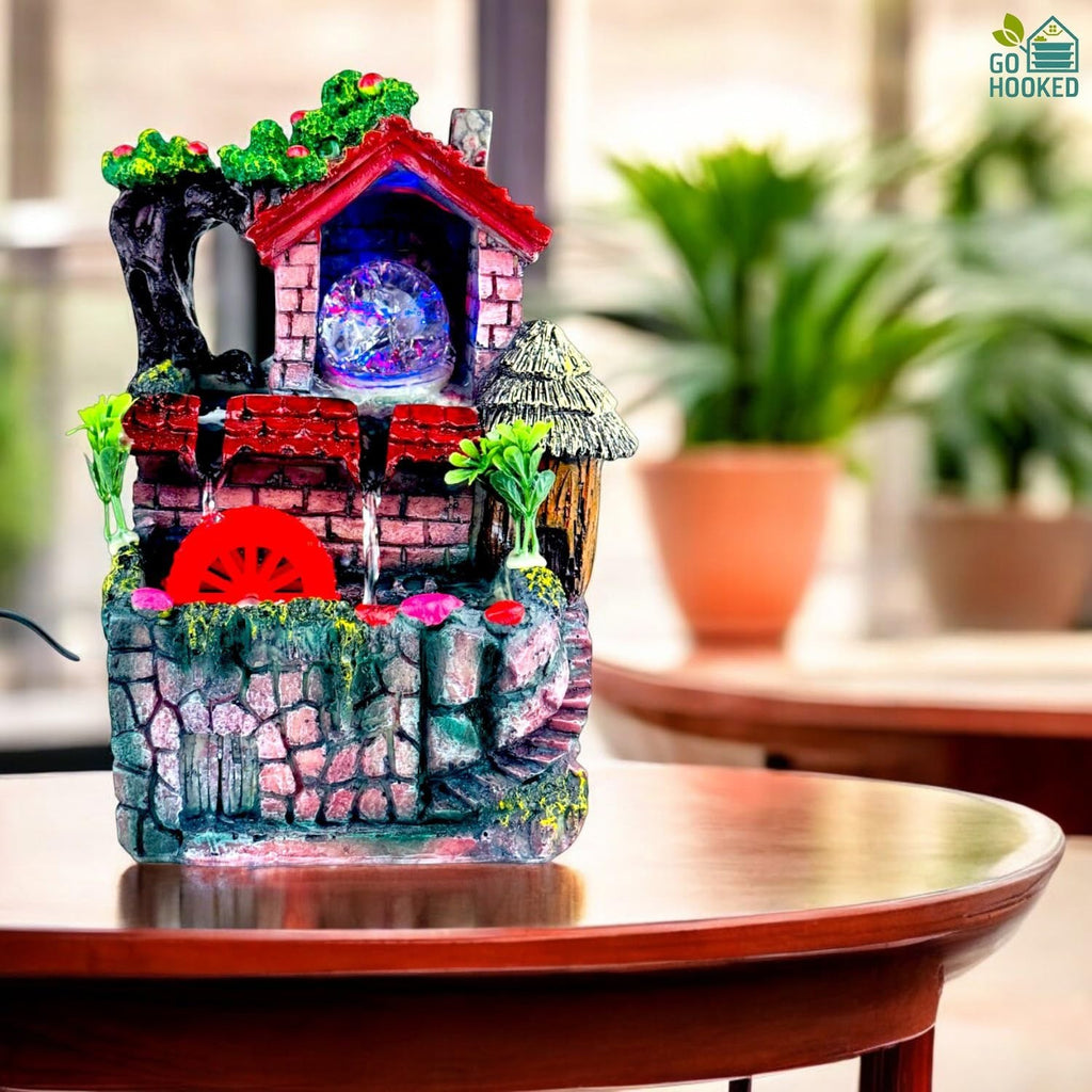 Go Hooked multicolor polyresin tabletop waterfall fountain with LED lights and red water wheel.