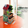 GoHooked multicolor polyresin waterfall fountain with LED lights and adjustable speed, designed as a house with barrels. 25.5 cm tall.