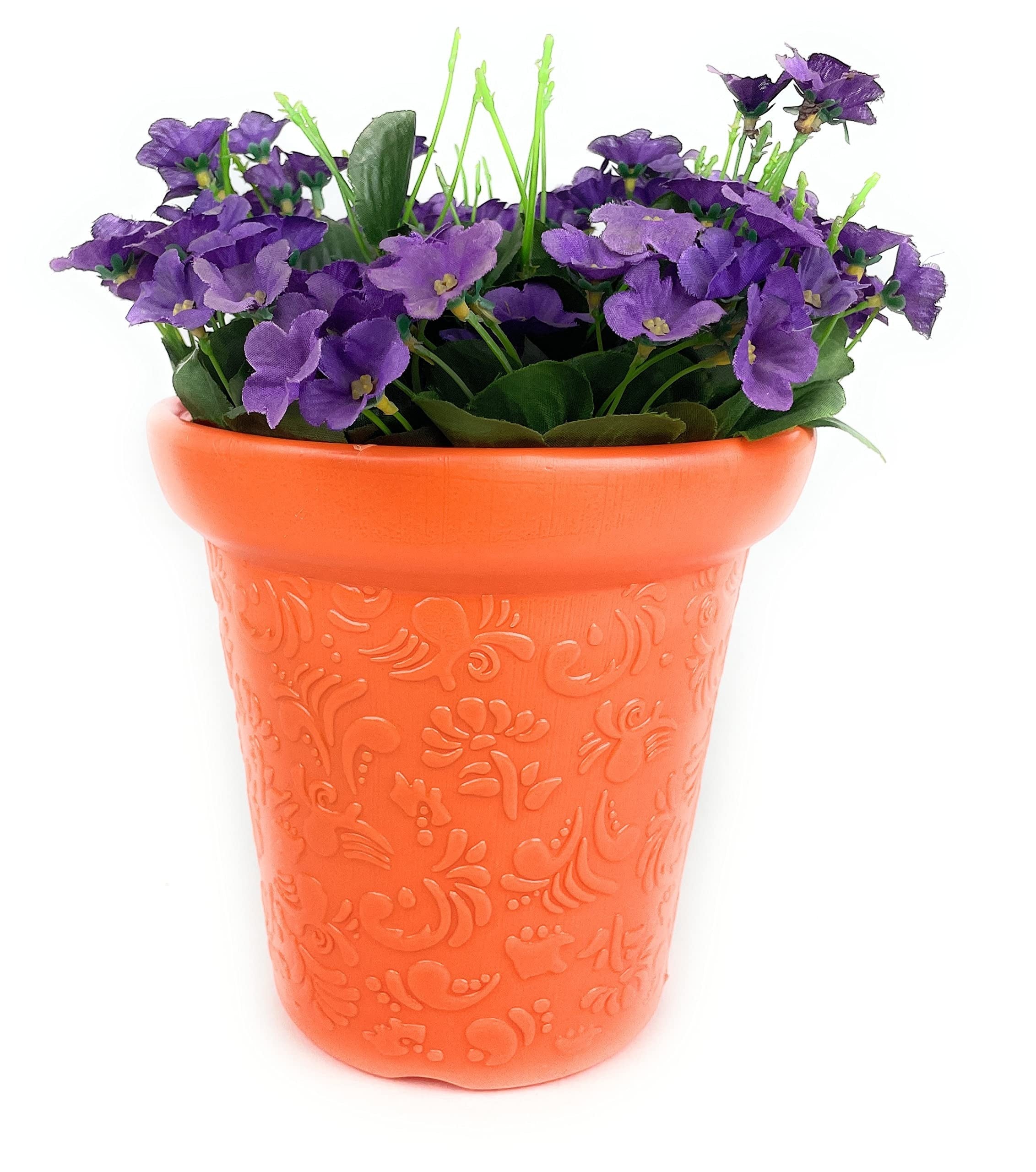 Go Hooked orange plastic planter pot with embossed floral pattern, holding purple artificial flowers.