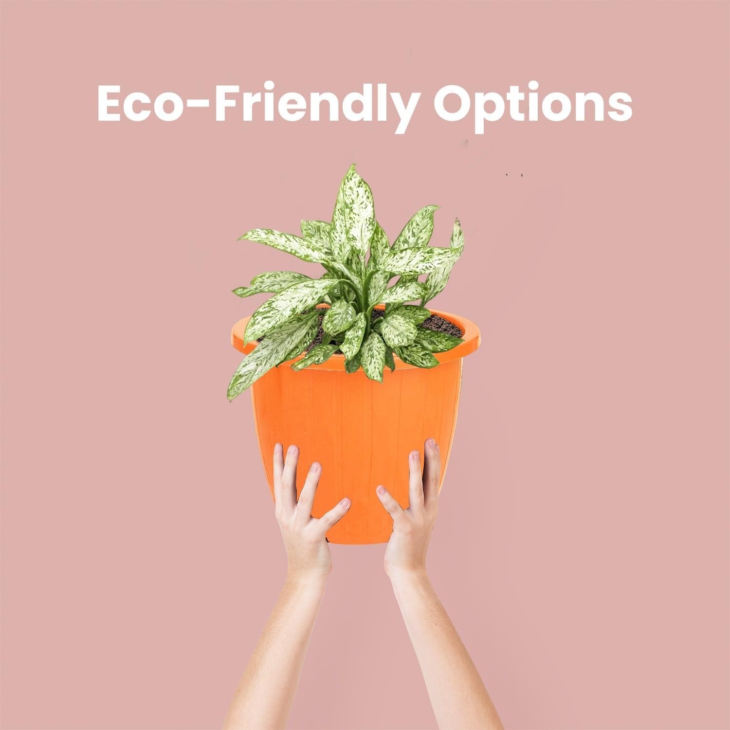 GoHooked orange plastic planter pot with a plant, held by two hands against a pink background.