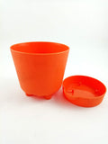 GoHooked orange plastic planter with drainage saucer, perfect for indoor or outdoor use.