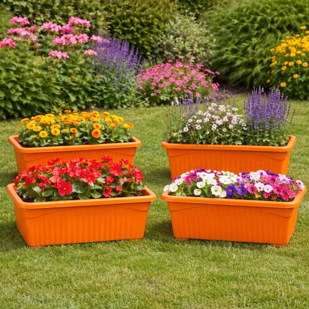 Go Hooked Set of 4 orange rectangular plastic planters filled with colorful flowers on a green lawn.