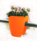 GoHooked orange plastic 12-inch railing planter with flowers and a pinwheel decoration.