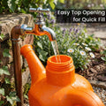 GoHooked orange plastic watering can with a wide opening being filled with water from a tap. Features a long spout and handle.