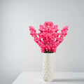 Go Hooked pink artificial flowers in a white textured ceramic vase, perfect for home or office decor.