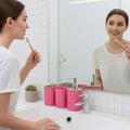 Go Hooked pink plastic bathroom accessory set with heart embossing, includes soap dispenser, tumbler, soap dish, and toothbrush holder.