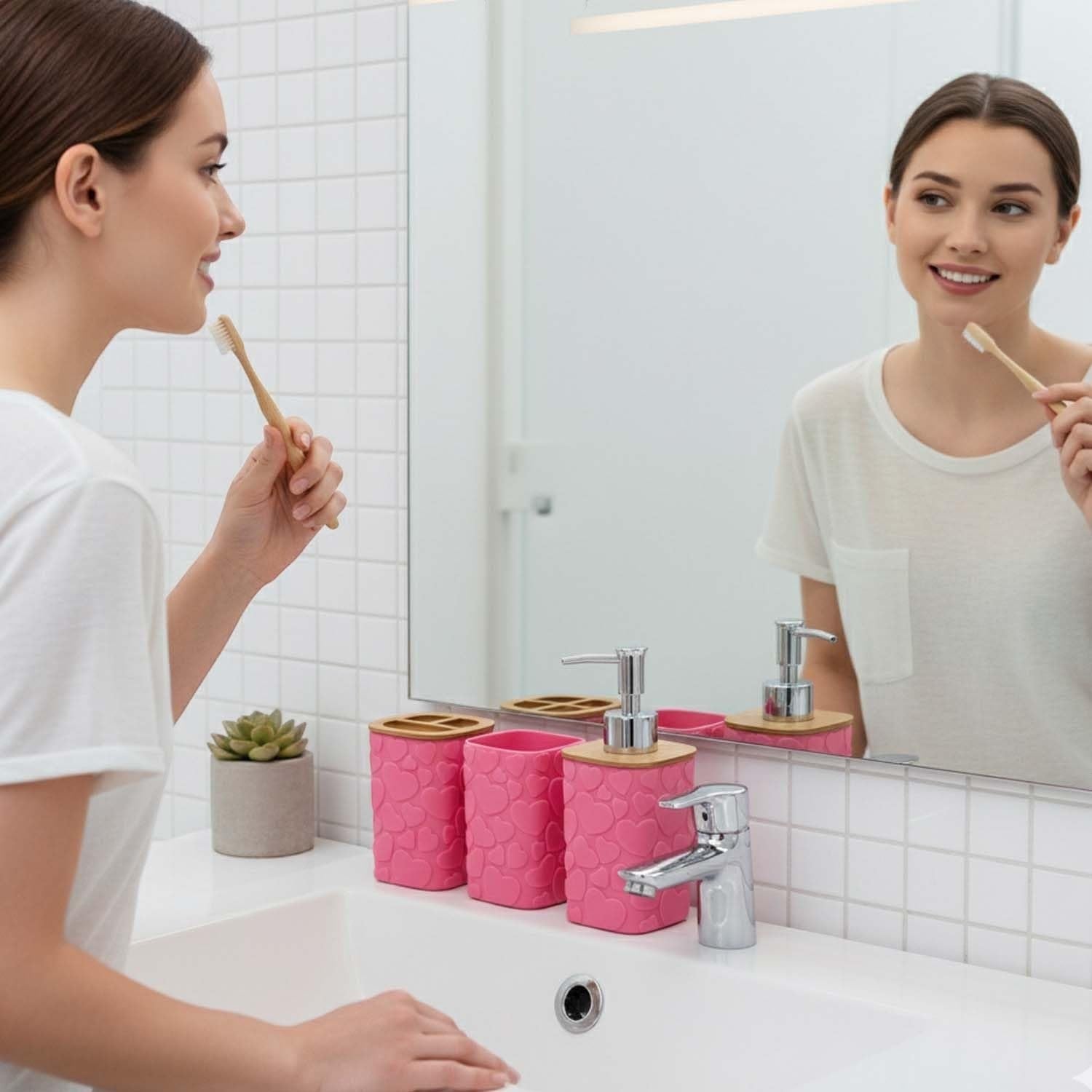 Go Hooked pink plastic bathroom accessory set with heart embossing, includes soap dispenser, tumbler, soap dish, and toothbrush holder.