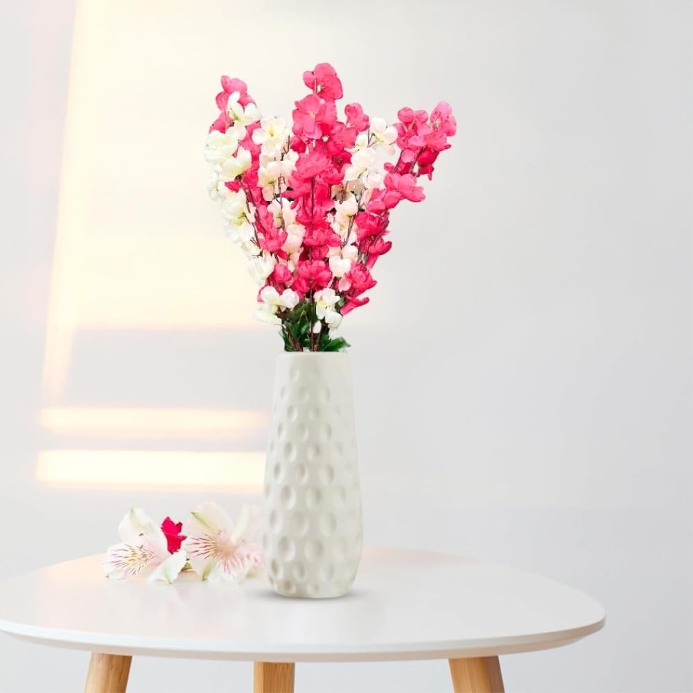 GoHooked pink and white artificial flowers in a textured white ceramic vase, with two loose flowers on the side.