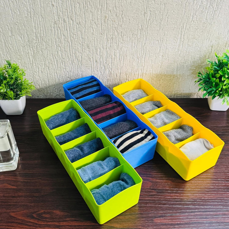 Go Hooked set of 3 multipurpose plastic drawer organisers in lime green, blue, and yellow, holding socks.