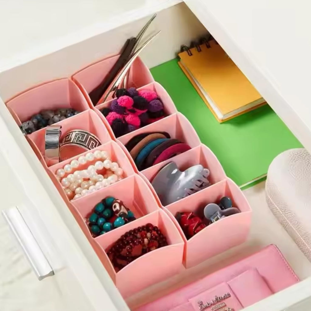 Go Hooked multicolour plastic 5-grid drawer organiser filled with jewellery, hair accessories, and stationery.
