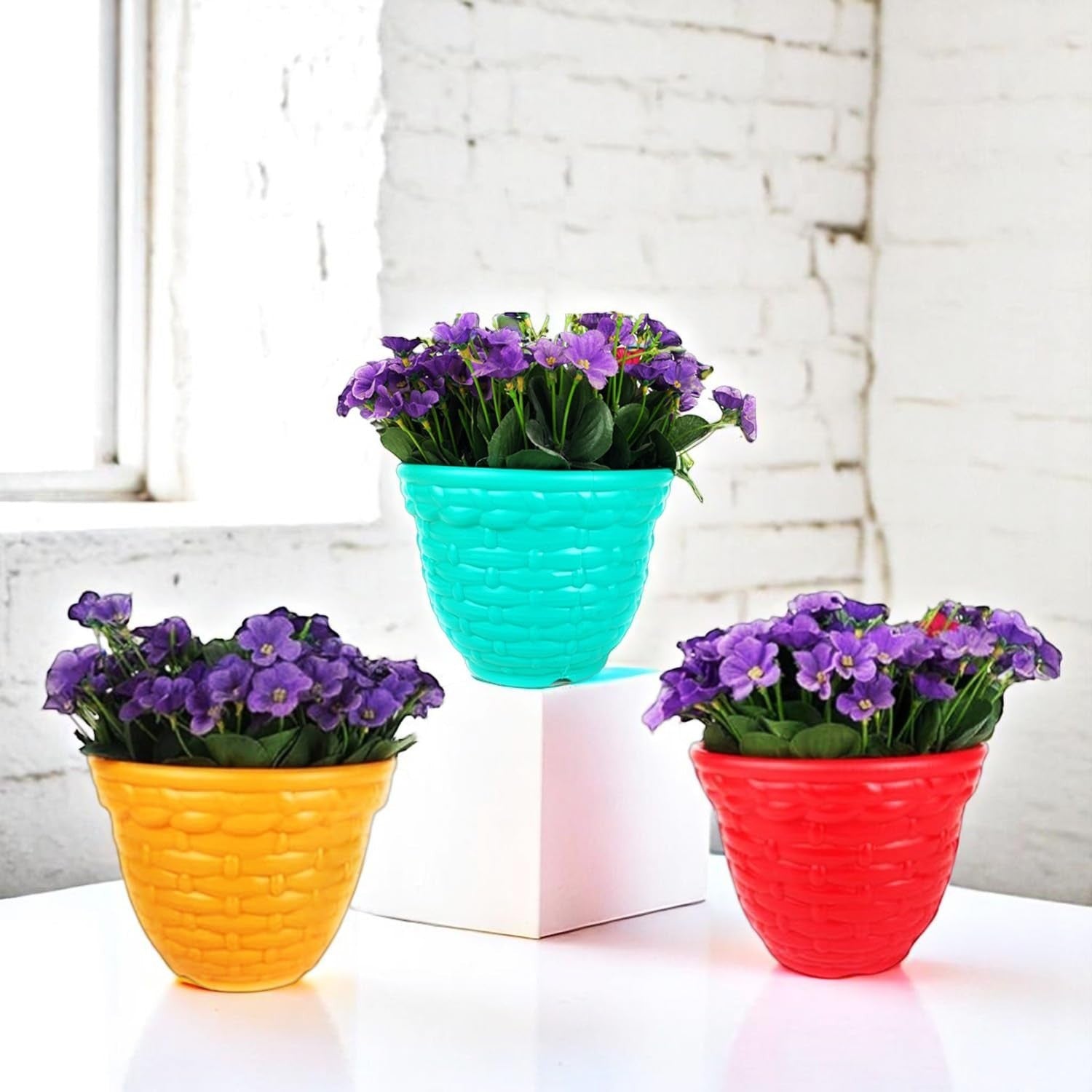 GoHooked set of 3 multicolor plastic planter pots with woven texture, holding purple flowers.