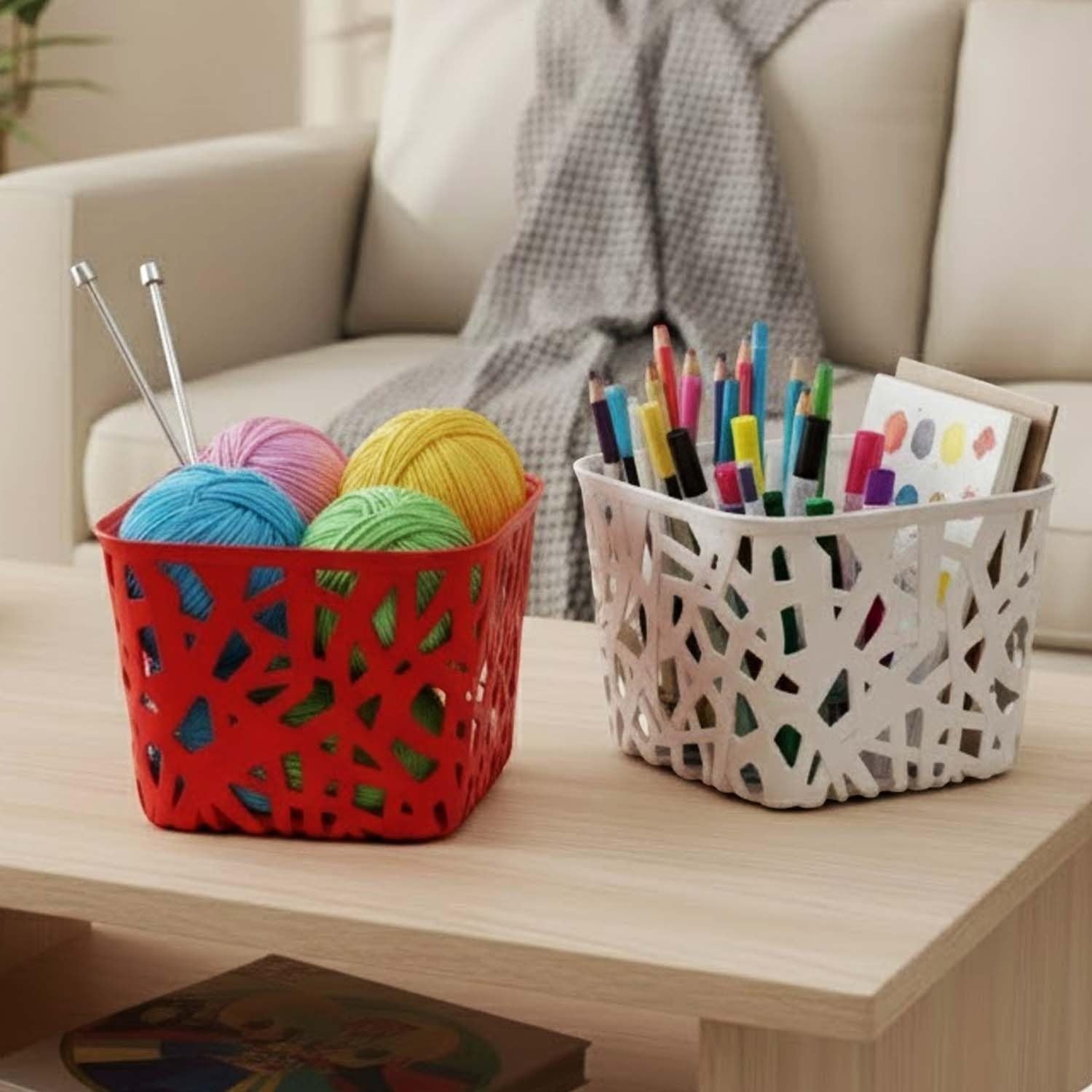 GoHooked multicolor plastic storage baskets with decorative cutouts, one red with yarn, one white with art supplies.