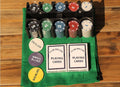 Go Hooked 200-piece multicolor poker chip set with dealer and blind buttons, two decks of playing cards on a green mat.