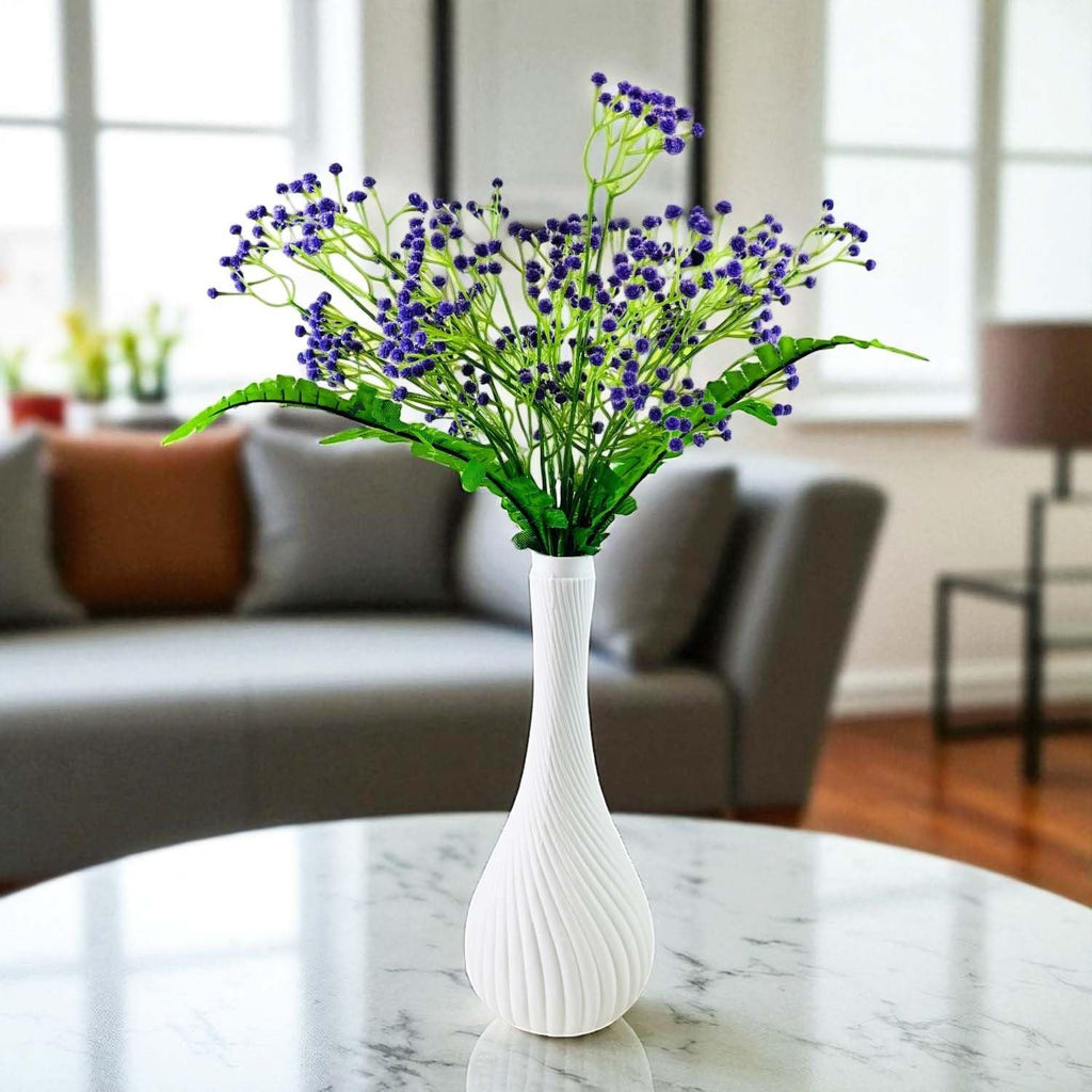 Go Hooked purple baby's breath artificial flowers with fern leaves in a white swirl vase on a marble table.