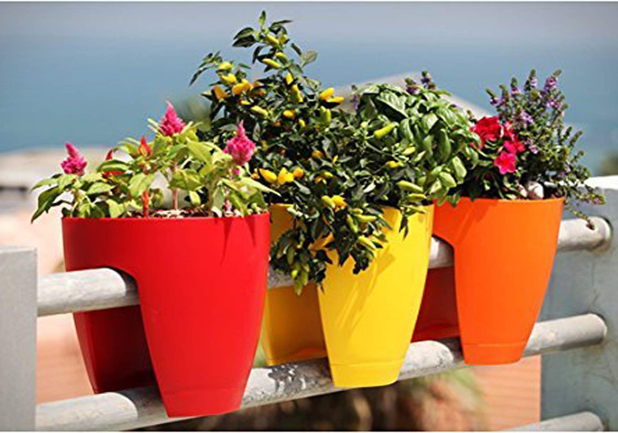 Go Hooked railing planters in red, yellow, and orange, made of plastic, perfect for balconies and patios.