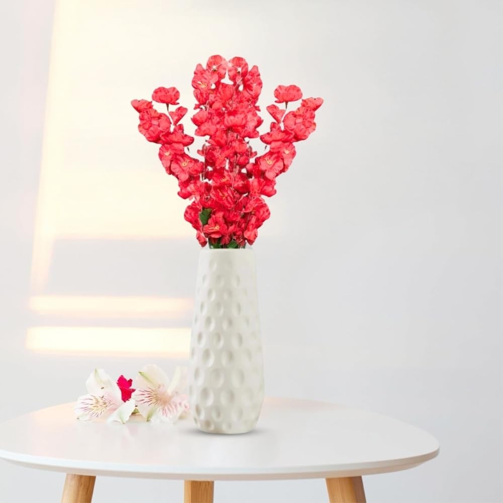 Go Hooked red artificial flowers in a white textured vase, with two white flowers on the side.