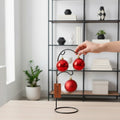 GoHooked red glitter Christmas ornaments hanging on a black stand, festive home decor.
