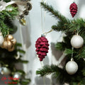 GoHooked red pine cone Christmas ornaments with glitter accents, hanging on a decorated tree.
