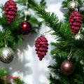 GoHooked red pine cone Christmas ornaments with glitter accents, hanging on a festive tree.