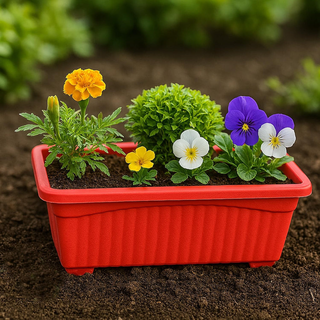GoHooked red rectangular plastic planter with fluted sides, holding marigolds, pansies, and a small green bush.