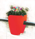 Go Hooked red plastic planter pot, 12 inch, with flowers and a colorful pinwheel decoration, designed to hang on railings.