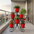 Go Hooked 6-pack of 10-inch red plastic planters on a black metal tiered stand on a balcony.