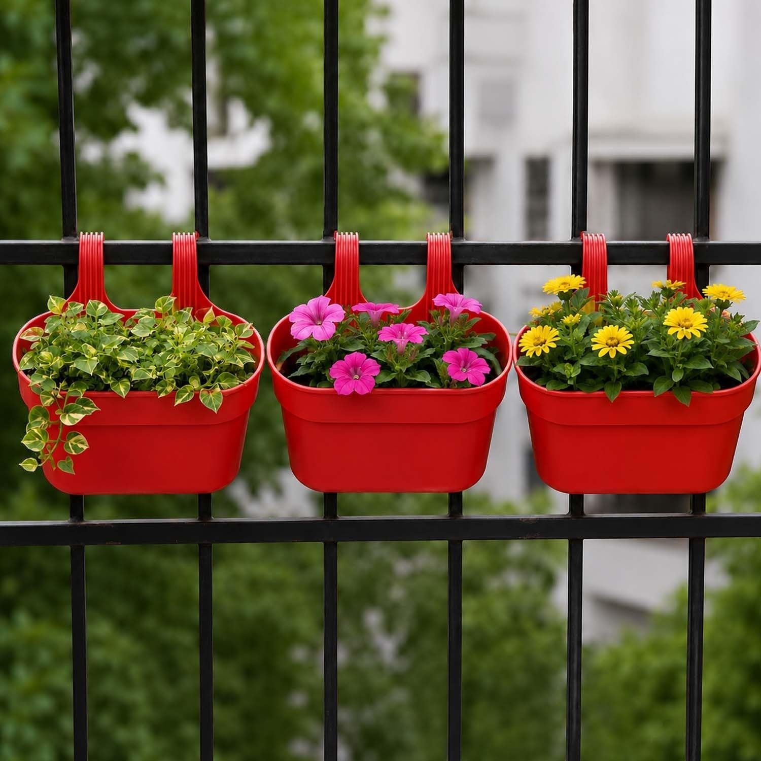 GoHooked set of 3 red plastic railing hanging planters with double hooks, holding green plants, pink flowers, and yellow flowers.