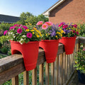 GoHooked red plastic railing pots filled with colorful flowers like pink gerbera daisies and purple petunias, 12-inch size.