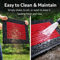 GoHooked red rubber door mat with a decorative black border and ribbed surface being cleaned outdoors.