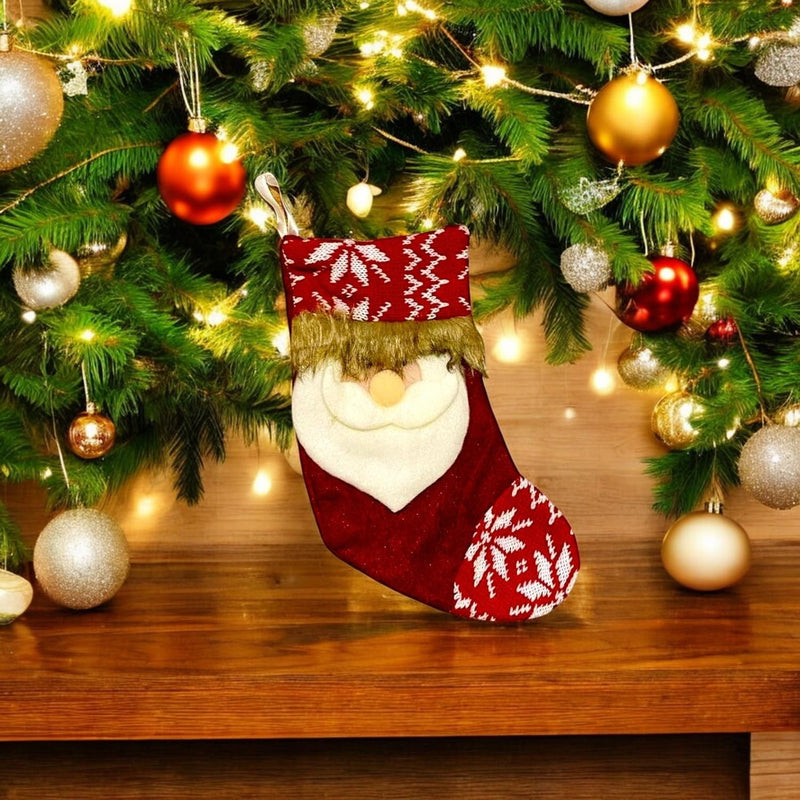 GoHooked red Santa Claus Christmas stocking with white snowflake pattern and gold trim, hanging on a decorated tree.