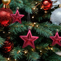 GoHooked red star Christmas ornaments with glitter accents, 3-inch, pack of 6, hanging on a decorated tree.