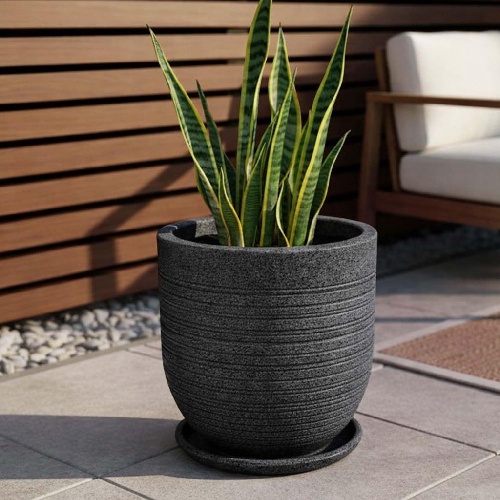 GoHooked Ripper 10 inch round planter pot in dark grey polymer with textured ribbed design and matching saucer. Holds a snake plant.
