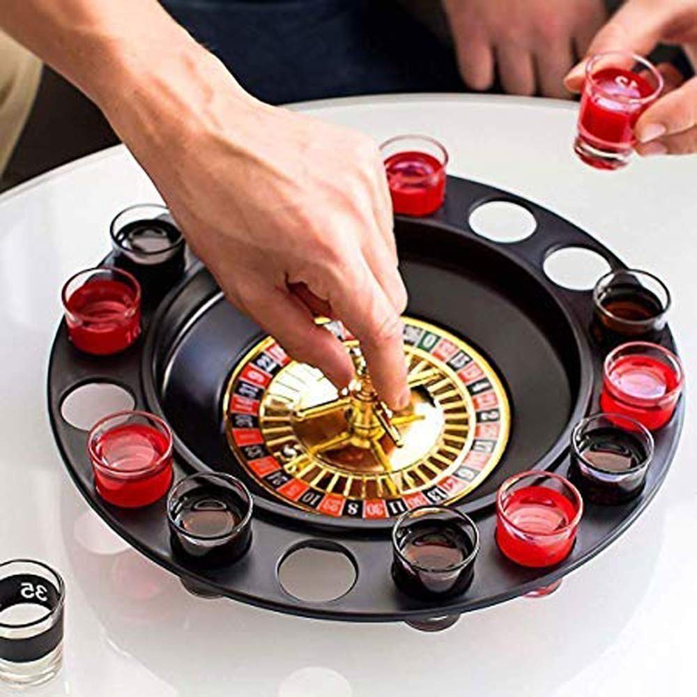 GoHooked roulette shot glass game set with black spinning wheel and clear glasses filled with red drinks on a table