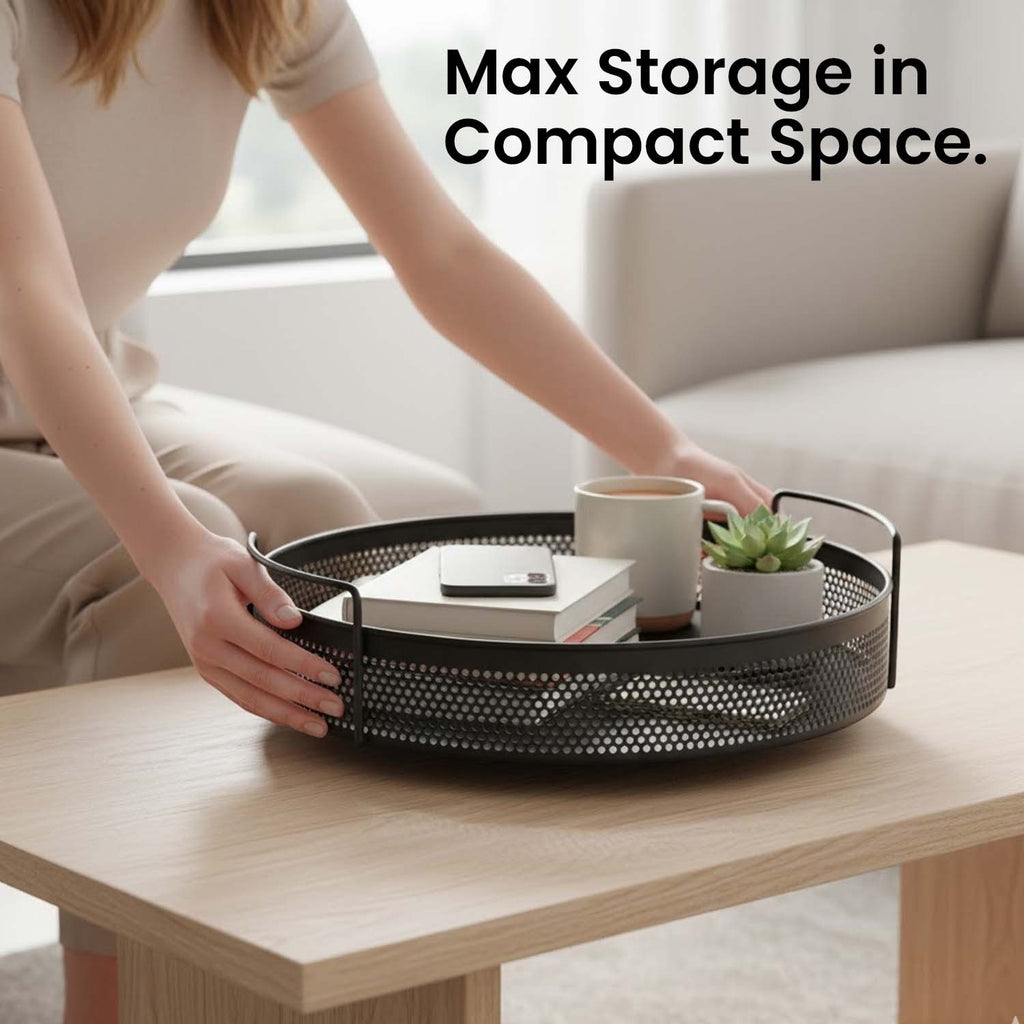 GoHooked round black metal storage tray with perforated design and side handles on a wooden coffee table.