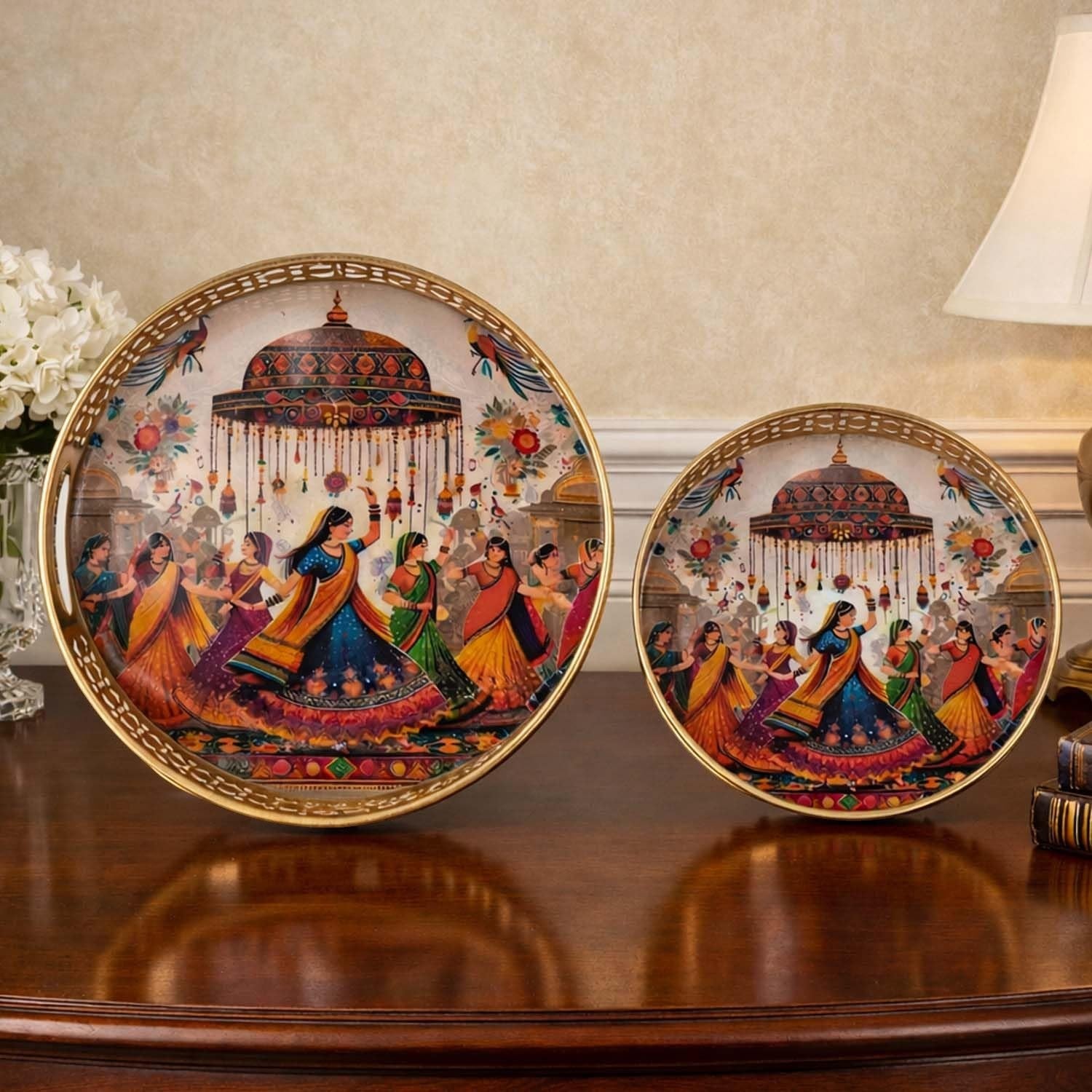 Go Hooked set of 2 round decorative metal trays with gold finish and Indian dancers motif. 8/10 inch.